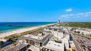 A coastal hotel with a beach view, a pier, and a parking lot. - Calypso 3-1511 (Panama City Beach)