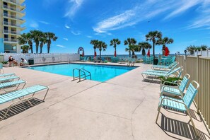 A pool area with lounge chairs and a view of the ocean. - Gulf Highlands 108 - Flip Flop Hideaway (Panama City Beach)