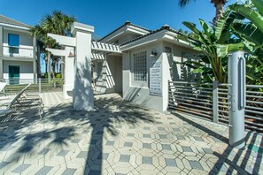 Enter a tranquil retreat with a gated entrance, surrounded by lush greenery and a beautifully tiled patio area.