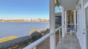 En balkon med udsigt over rolige vandflader og bygninger i det fjerne.
