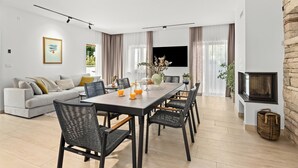 A modern living room with a dining area, a fireplace, and a flat-screen TV. - Casa Dika Pool & Lounge, Barban, Croatia (Barban)