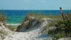 A beach with clear turquoise water, sandy dunes, and sparse vegetation. - Town of Prominence 67C - Pour Beach Life (Santa Rosa Beach)