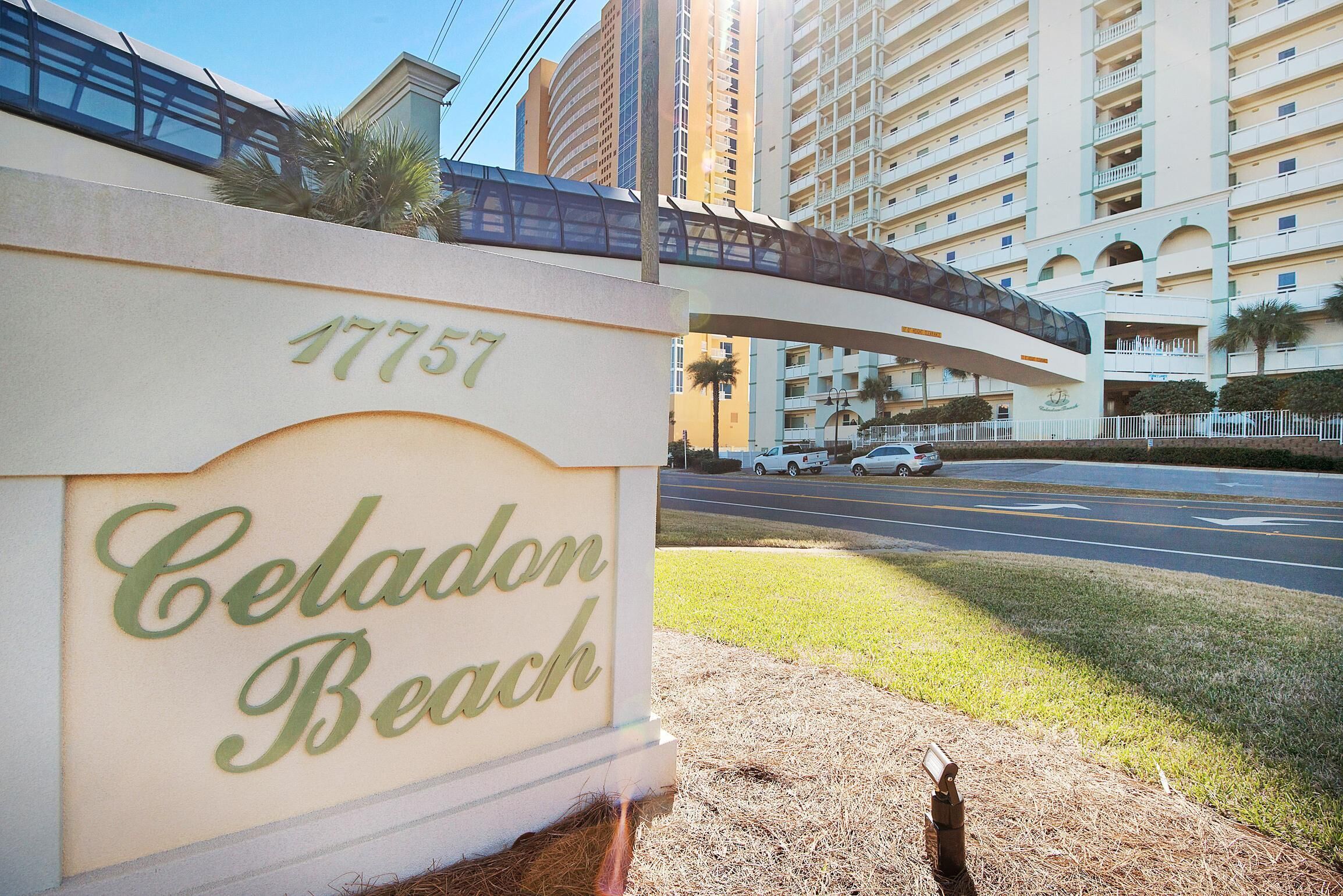 Un panneau indiquant « Celadon Beach », avec en arrière-plan un immeuble à plusieurs étages et une route.