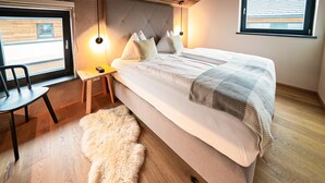 A bedroom with a bed, a chair, a small table, a fluffy rug, and a window with blinds. - Lovely home in Rennweg am Katschberg (Rennweg am Katschberg)