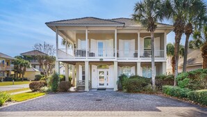 A two-story house with a covered front porch and a balcony on the second floor. - Emerald Mist (Miramar Beach)