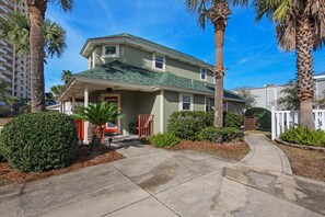 A two-story house with a green roof, a front porch, and a driveway. - Aloha Cottage (Miramar Beach)