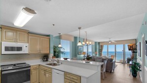 A modern kitchen with a central island, built-in appliances, and a view to the outside. - Leeward Key 806 (Miramar Beach)