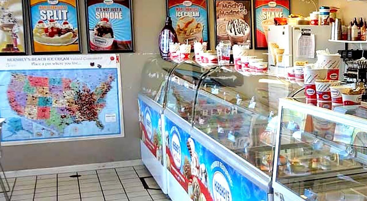An ice cream parlor with a variety of ice cream flavors and toppings displayed in the case.
