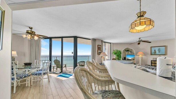 A spacious balcony with a dining area, wicker furniture, and a view of the ocean. - Aquavista 504w (Panama City Beach)