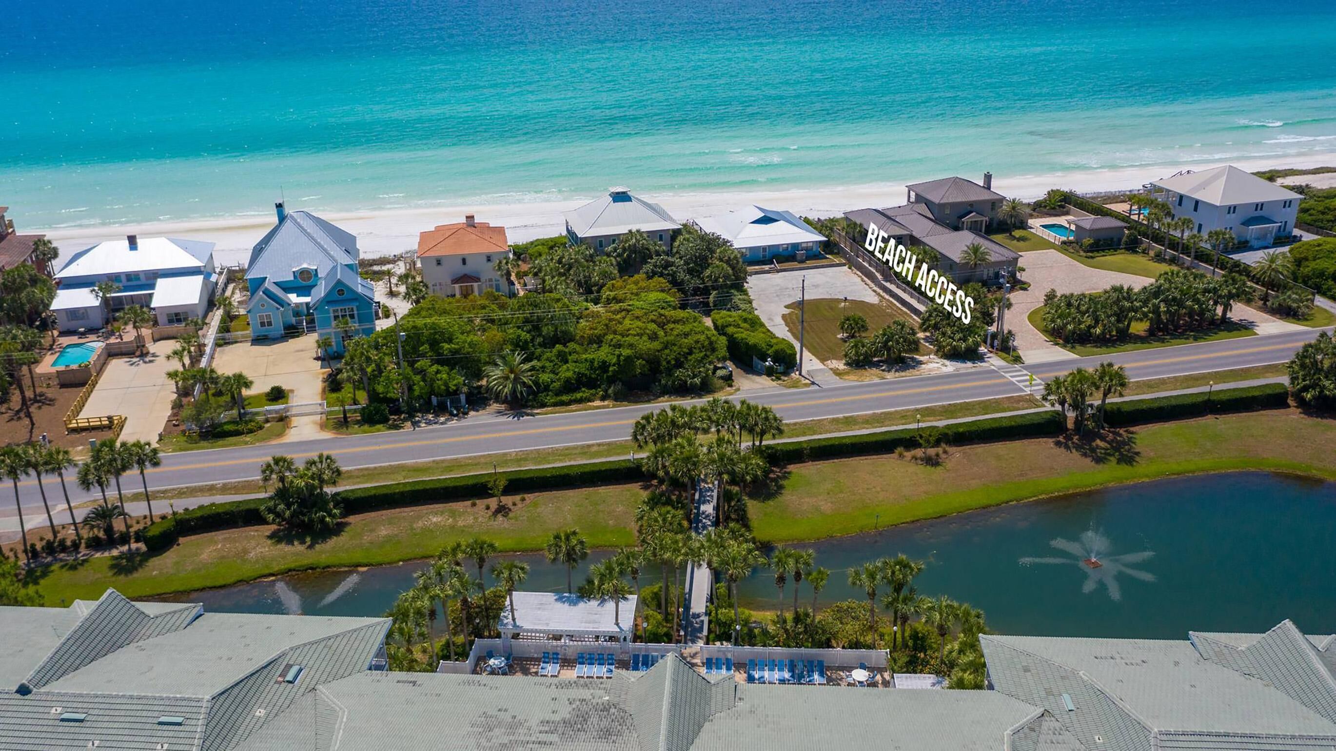 A coastal residential area with houses, a beach, and a body of water.