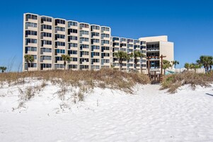 A multi-story hotel with a modern design, featuring a flat roof and a series of balconies.