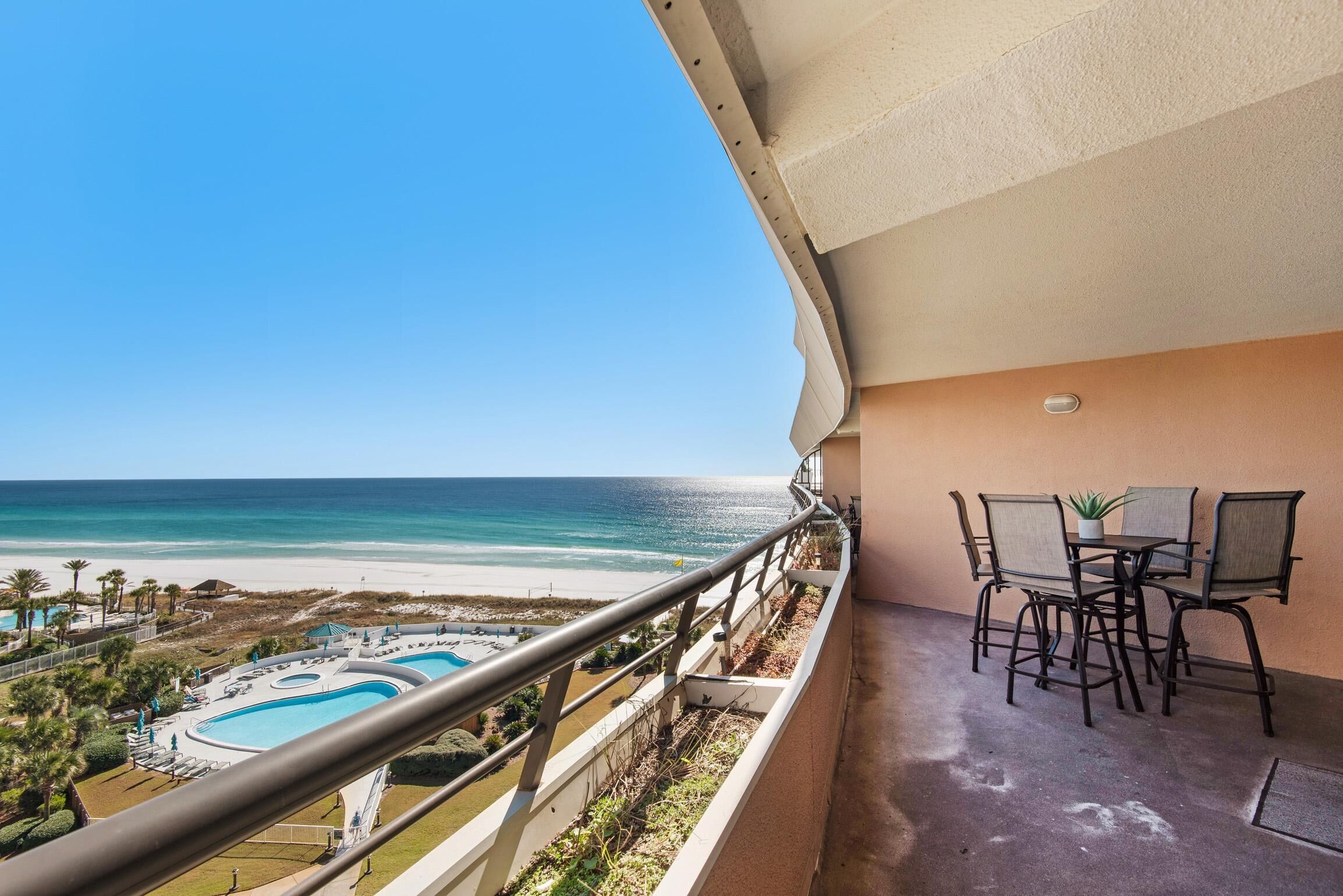 Ein Balkon mit Blick auf Strand und Pool.