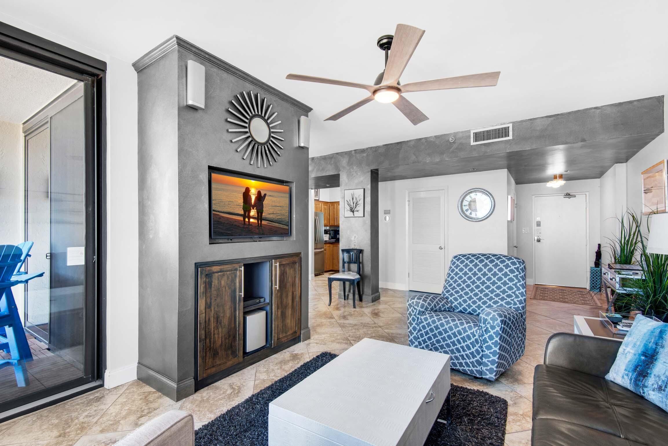Un salon moderne doté d’une cheminée, d’un ventilateur de plafond et d’un coin repas.