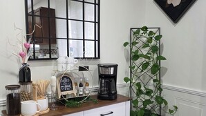 A kitchen counter with a coffee maker, a potted plant, and a fire extinguisher.