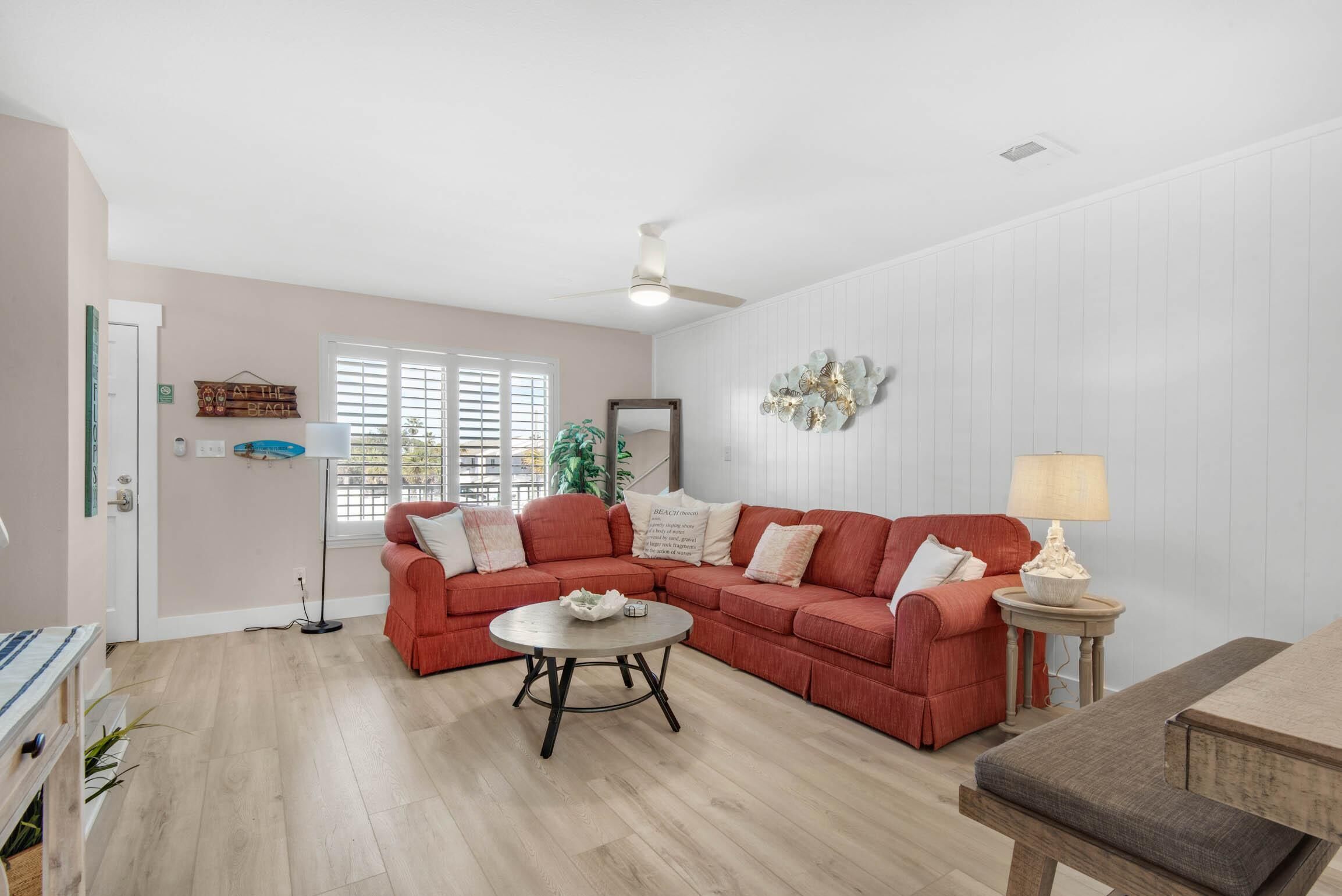 A living room with a sectional sofa, a round coffee table, and a lamp.