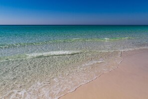 Una platja amb aigua turquesa cristal·lina i sorra daurada.