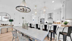 A modern kitchen with white cabinetry, a central island, and pendant lighting. - Keeping It Reel on 30A (Santa Rosa Beach)