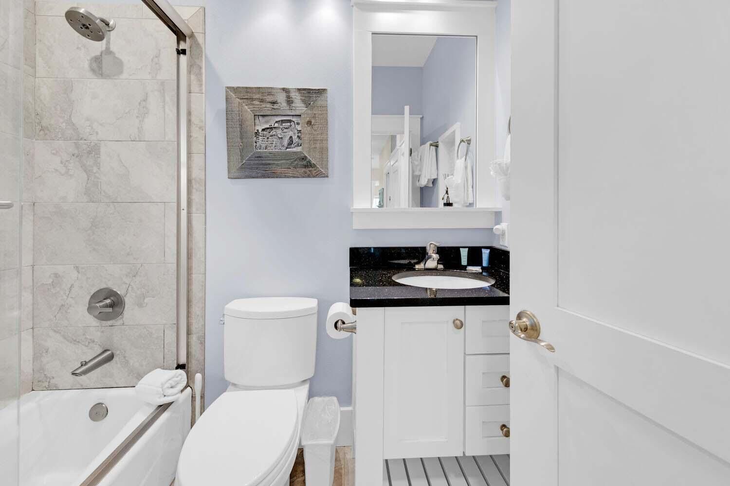 A modern bathroom with a shower, toilet, and sink.