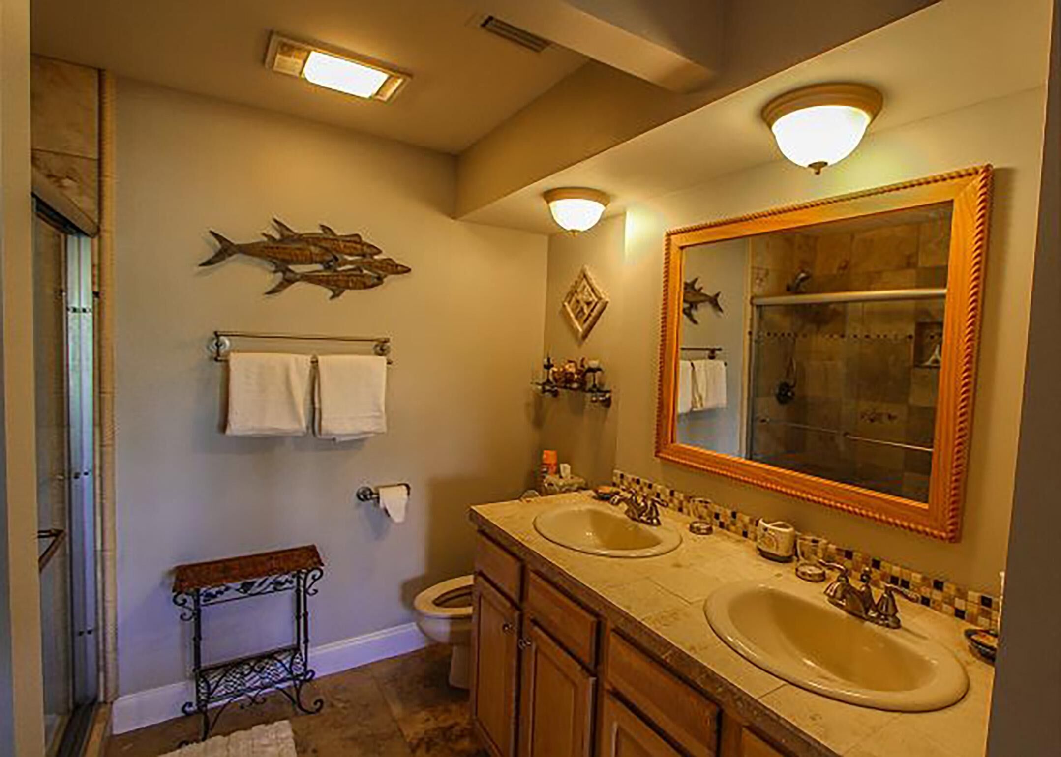 A bathroom with two sinks, a large mirror, and a towel rack.