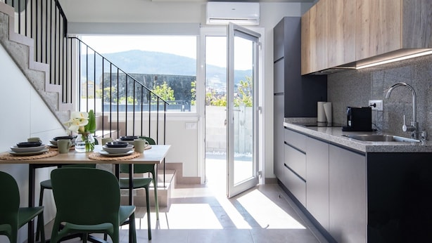 Una cocina moderna con estufa integrada, un lavamanos y un comedor con mesa y sillas.
