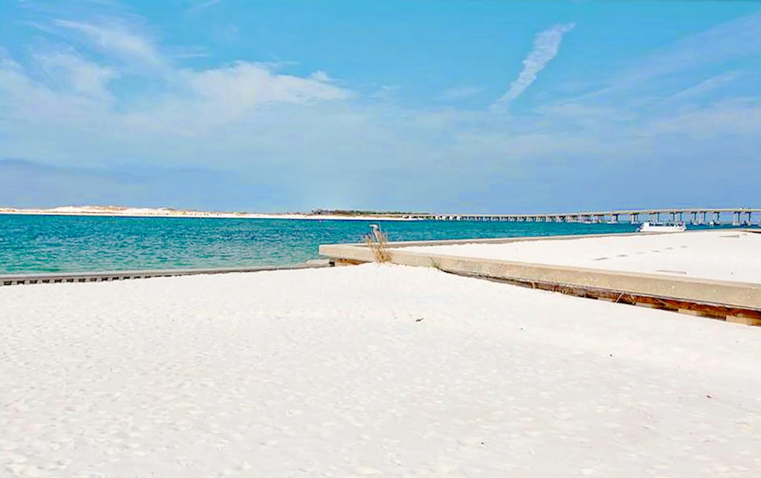 Ein Strand mit einem Steg, der sich ins Wasser erstreckt.