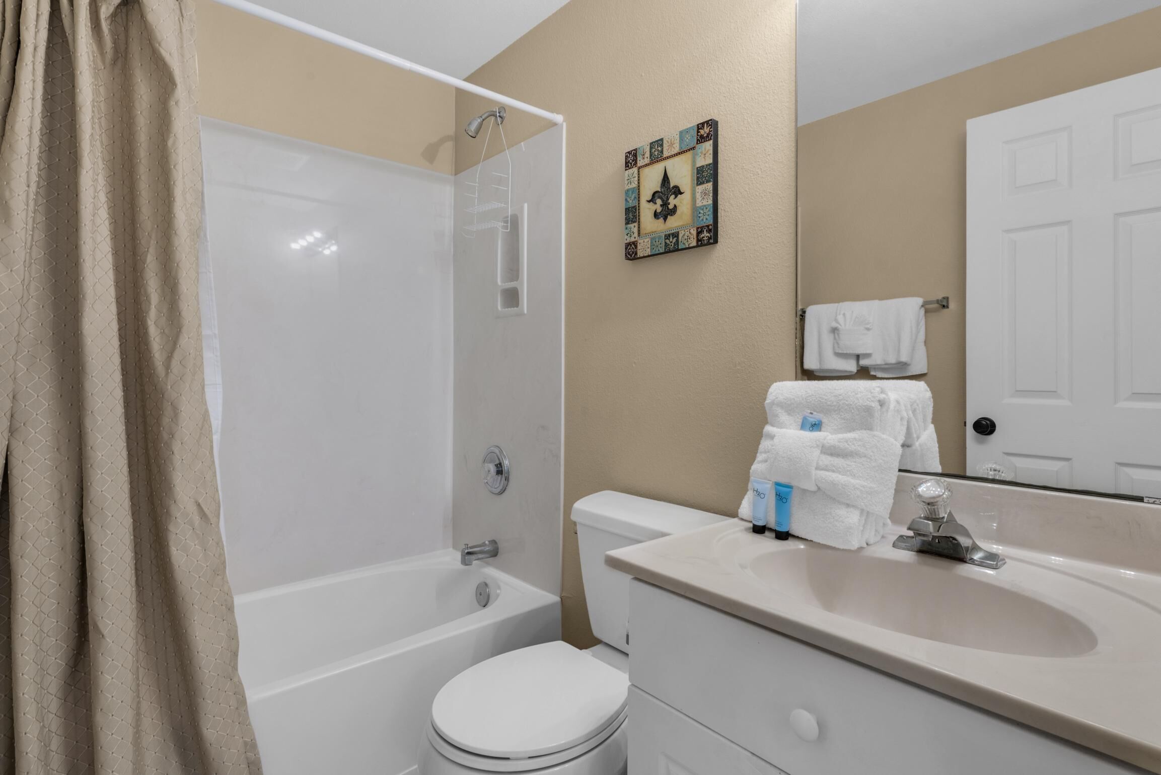 Un bagno con vasca, toilette, lavandino e porta asciugamani con asciugamani.
