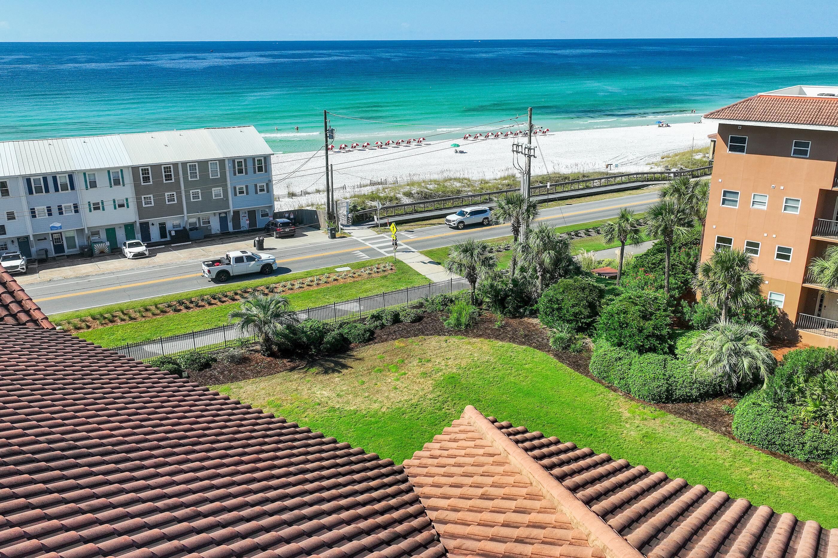 Ein Küstenblick mit Strand, einer Straße und Gebäuden.