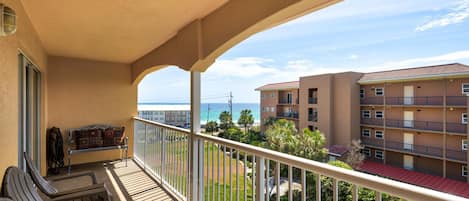 Ein Balkon mit Blick auf das Meer und einen Gebäudekomplex.