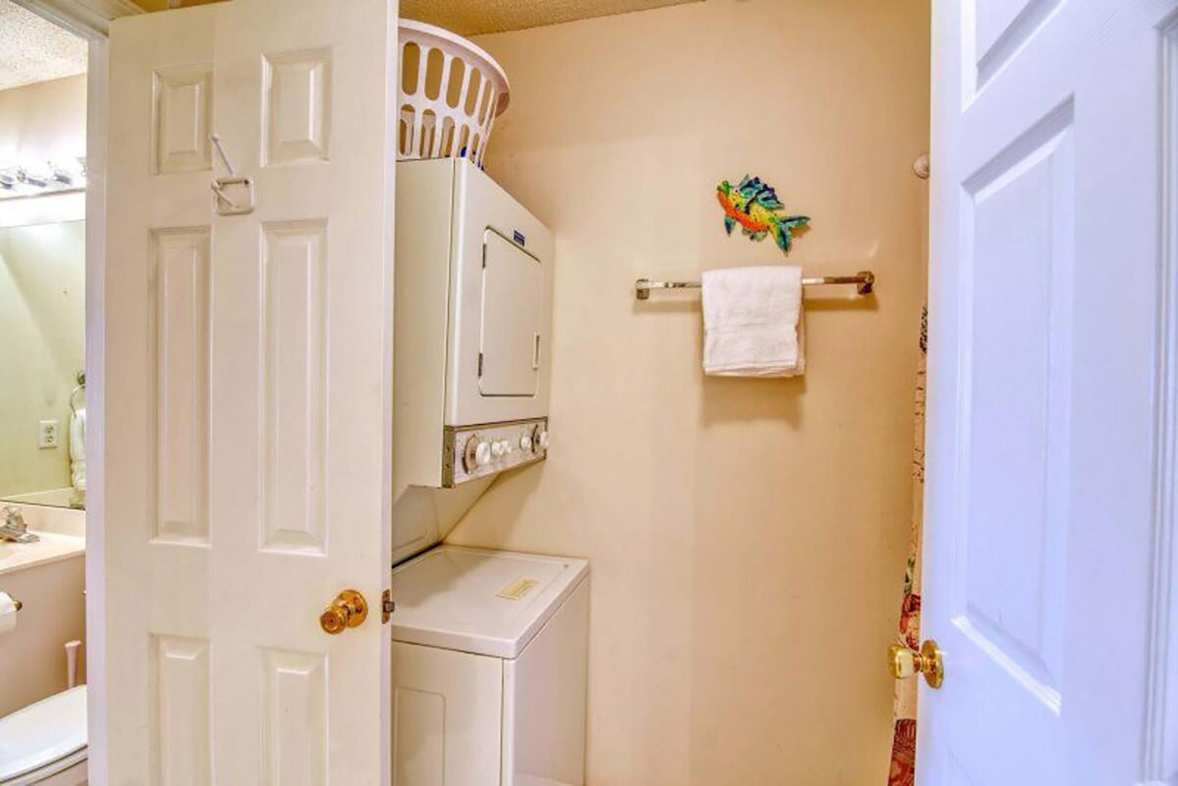 A laundry room with a washing machine, dryer, and stacked laundry baskets.