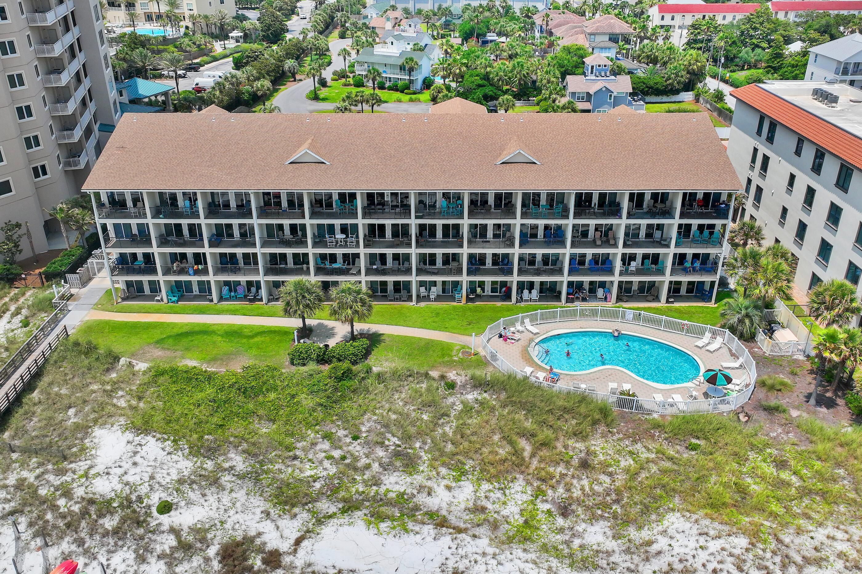 A multi-story hotel with a rooftop pool and a landscaped lawn.