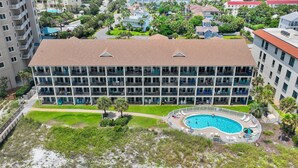 A multi-story hotel with a rooftop pool and a landscaped lawn.