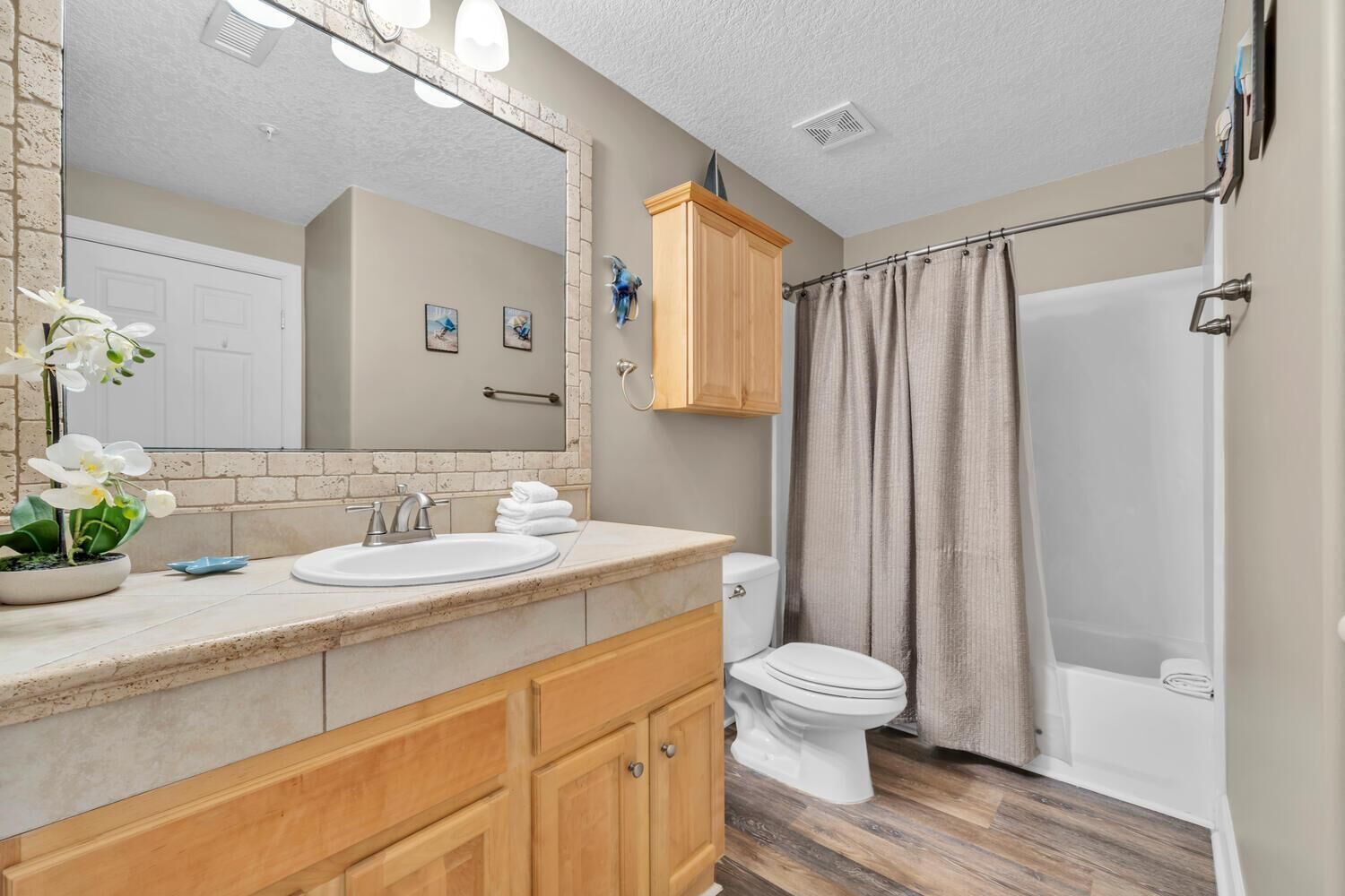 A bathroom with a sink, toilet, and shower.