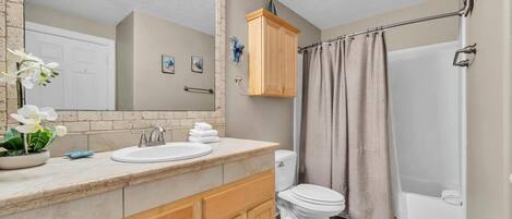 A bathroom with a sink, toilet, and shower.