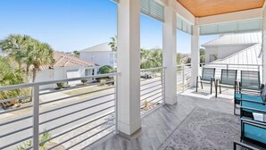 A covered balcony with a wooden ceiling, metal railings, and outdoor seating. - Sea Ya Sun (Miramar Beach)