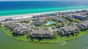 An aerial view of a coastal resort with multiple buildings, a beach, and a pool area. - Seascape Lakefront Villas 189- Don't Worry, Beach Happy (Miramar Beach)