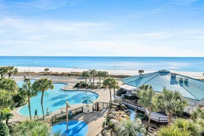 A resort with a large swimming pool, a beach view, and a building with a blue roof. - Edgewater Tower 1-411 (Panama City Beach)