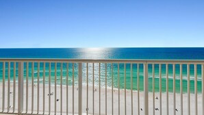 A balcony with a view of the ocean and beach.