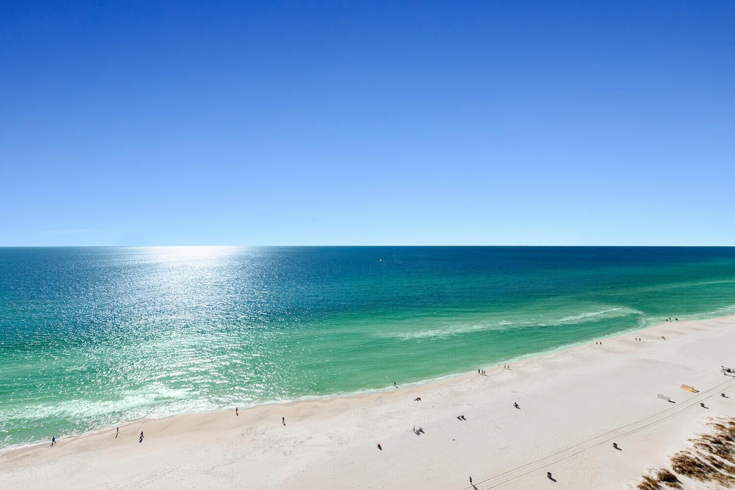 Ein Strand mit klarem türkisblauem Wasser und einem sandigen Ufer.