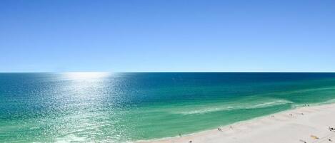 Ein Strand mit klarem türkisblauem Wasser und einem sandigen Ufer.