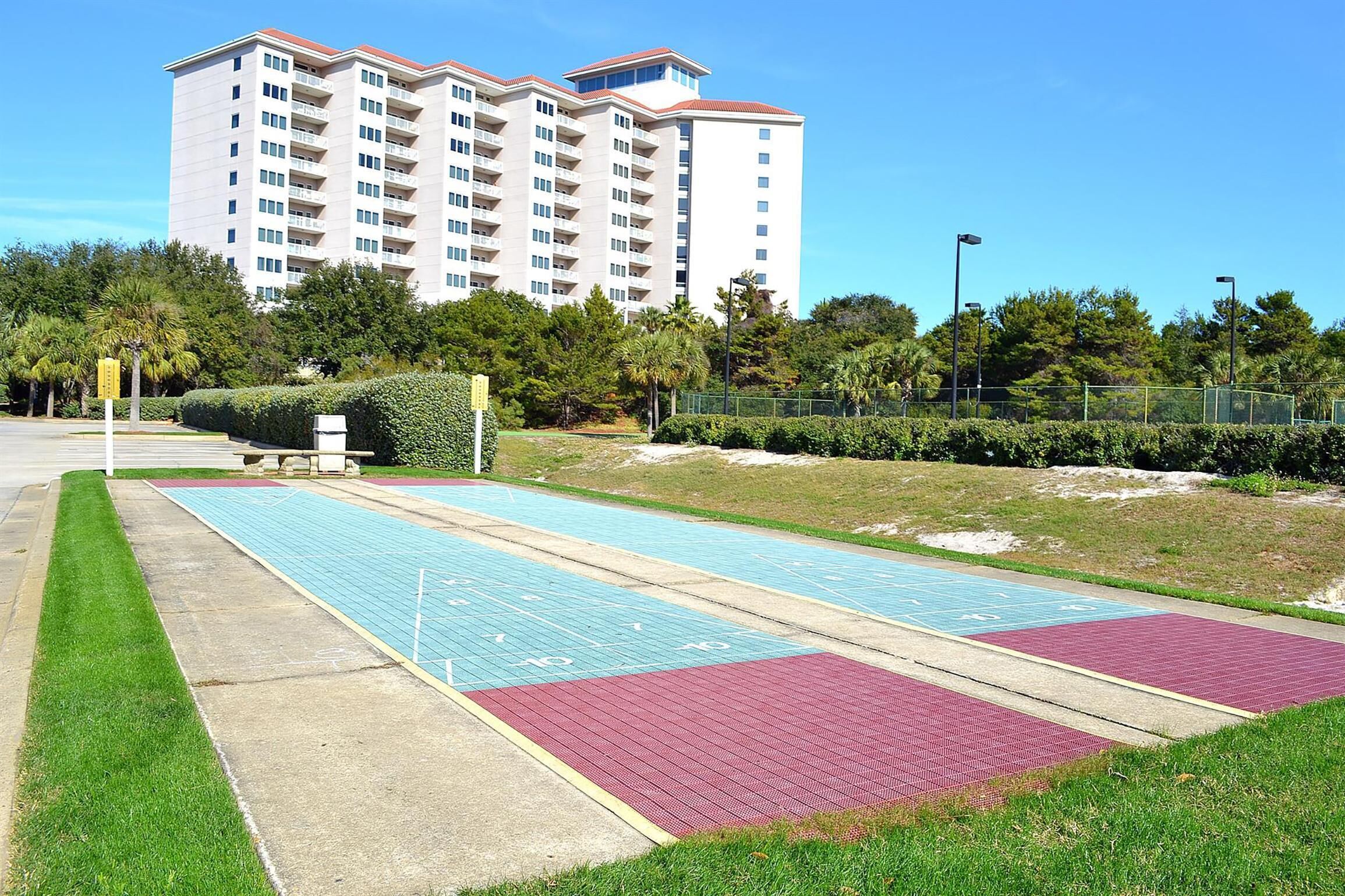 A swimming pool area with a multi-level building in the background.