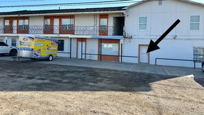 Un motel de una sola planta, un estacionamiento y un camión de mudanzas.