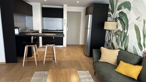 A modern apartment with a kitchen, dining area, and living room. - La Voile du Rocher (Nouméa)