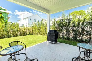 Enjoy al fresco dining on the patio, surrounded by lush greenery and a barbecue grill.