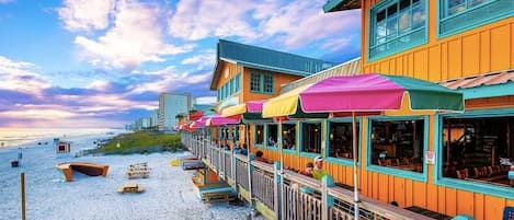 Un hôtel situé en bord de mer, doté d’une terrasse et d’une plateforme en bois.