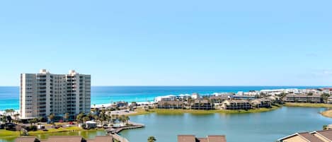 A coastal resort area with a large hotel, a marina, and a lake.