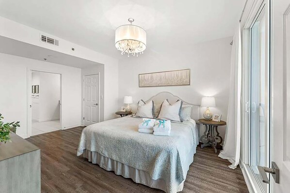 Cozy retreat with a large bed, bedside tables, and a chandelier.
