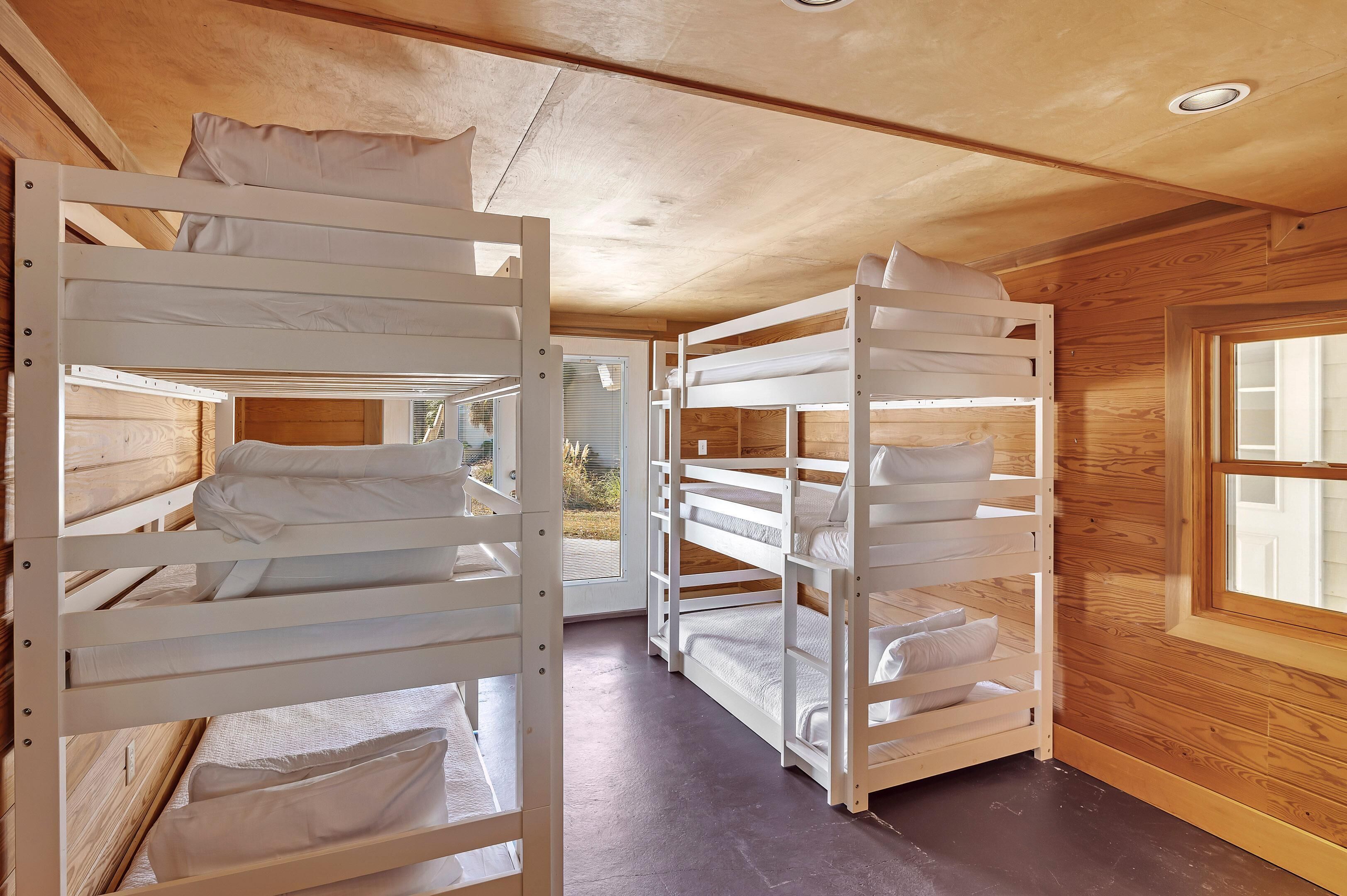 Una habitación con literas, paredes de madera y una ventana.