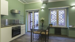 Una cocina moderna con estufa a gas, horno y una mesa con sillas.
