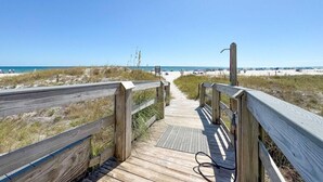 A wooden boardwalk leading to a beach with clear skies. - Summer House 1203a (Orange Beach)