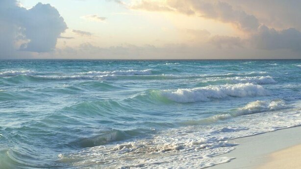 A beach with waves and a cloudy sky. - Barefoot Bungalow at Rookery (Gulf Shores)